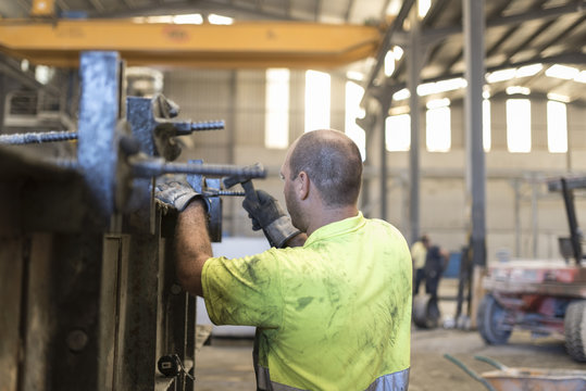 Man adjusting concrete structure in construction factory. Adjusting the mold to create a piece of cement