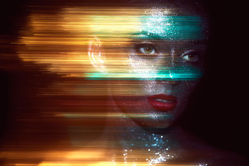 Portrait of Beautiful Woman with Sparkles on her Face. Girl with Art Make-Up in Color Light....