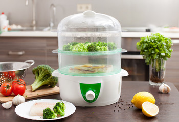 The steamer with the fish and broccoli in the kitchen - obrazy, fototapety, plakaty