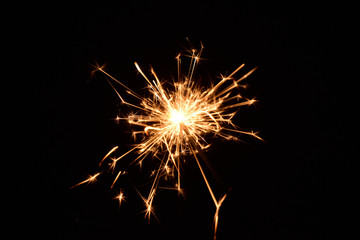 Fototapeta premium Blank background with bengal fire .Sparkler . New year party sparkler on black background A man holds a burning Bengal flame in his hands