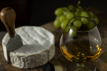 Close up of French Brie Cognac and grapes on a wooden board