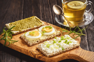 Rye crisp bread sandwiches with eggs, pesto and cottage cheese.