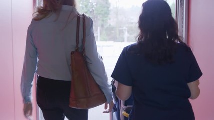 Dolly shot of female doctor with coworker pushing patient sitting in wheelchair