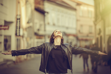 Portrait of a cheerful european woman with hands raised pointing up