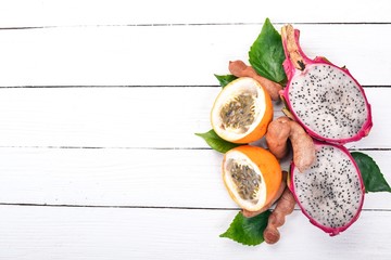 Dragon Fruit, Granadilla, Tamarind and Papaya. Fresh Tropical Fruits. On a wooden background. Top view. Copy space.