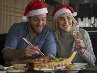 Pareja de navidad comiendo sushi en un restaurante.