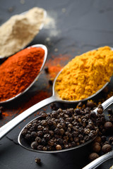 Various spices spoons on stone table.On dark concrete background.Herbs and spices on wooden table.  Top view with space for your text
