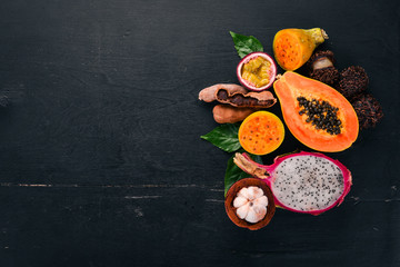 Papaya, Dragon Fruit, Cactus Fruit. Fresh Tropical Fruits. On a wooden background. Top view. Copy space.