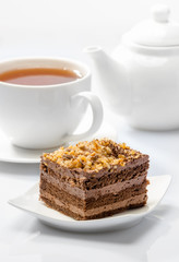cake on background of cup with tea and teapot