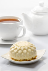cake on background of cup with tea and teapot