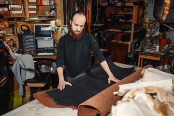 Working process in the leather workshop. Tanner in old tannery.
