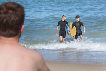 teens having fun with a bodyboard at the beach