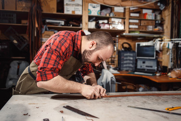 Working process in the leather workshop. Tanner in old tannery.