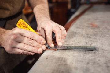 Close up of hands tanner performs work on table with tools