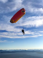 paraglider is flying in the blue sky