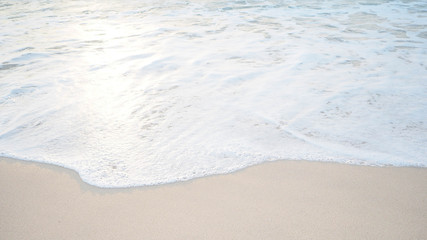 Fototapeta na wymiar Soft wave of the tropical sea on the sandy beach.