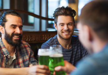 male friends drinking green beer at bar or pub