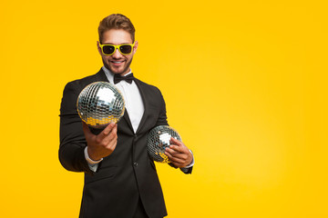 Young man in suit with disco balls