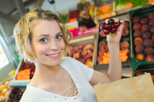 beautiful woman choosing ripe organic cherries