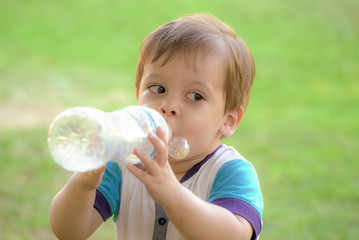 baby with a bottle of water in the park