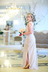 Fototapeta na wymiar beautiful blonde bride with a bouquet of white roses