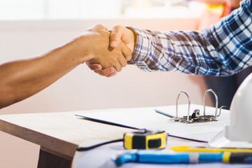 Architect contractor shaking hands with client after seal a deal to renovate building.