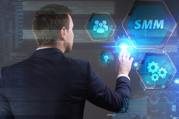 Business, Technology, Internet and network concept. Young businessman working on a virtual screen of the future and sees the inscription: SMM