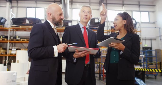 4K Management team in warehouse checking inventory & looking over the figures. Slow motion.