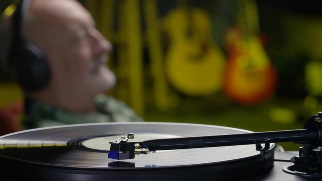 Older man listening to records on a turntable