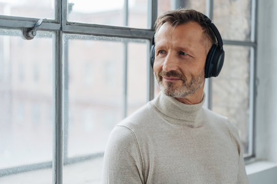 Smiling middle-aged man listening to his music