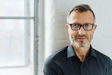 Bearded man wearing glasses looking at camera