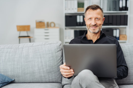 Attractive middle-aged man relaxing with a laptop