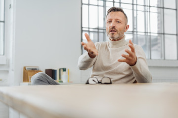 Middle-aged man sitting explaining something