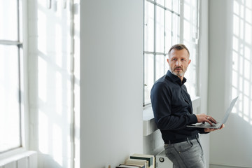 Fototapeta premium Relaxed businessman using a handheld laptop