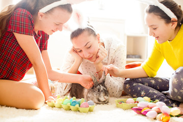 Obraz na płótnie Canvas Girlfriends playing with rabbit