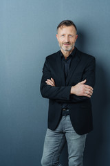 Confident middle-aged man in jeans and jacket