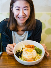 Yong lady smiling with Bibimbap