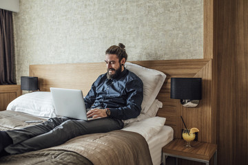 Fototapeta premium Businessman Typing on Laptop at Hotel