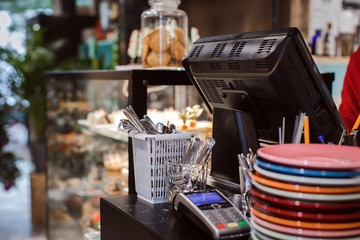 Working area in cafe. Cash desk and showcase with sweets in a cafe