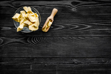 Cocoa butter for homemade cosmetics. Dark grey wooden background top view copy space