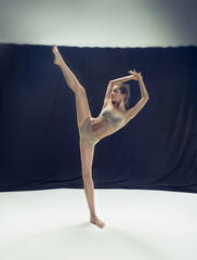 Young teen dancer ion white floor background.