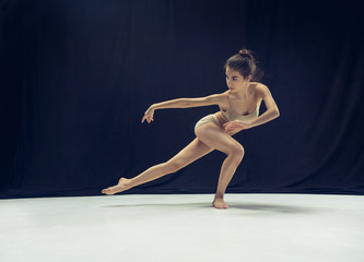 Young teen dancer ion white floor background.