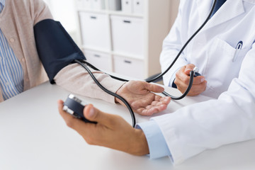 doctor with tonometer and senior woman at hospital
