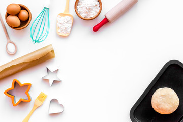 Ball of fresh raw dough near ingedients and cookware on white background top view copy space