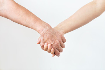 close up of senior and young woman holding hands