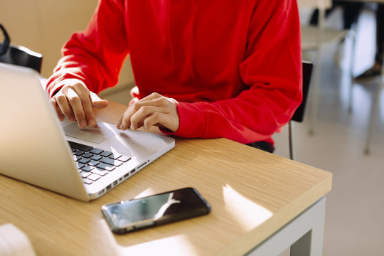 Midsection of man using laptop computer while sitting at table in library
