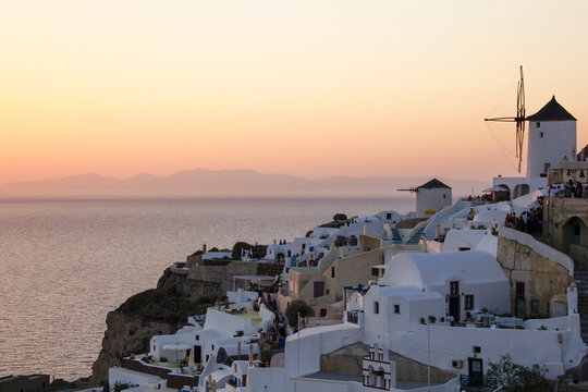 High angle view of windmill amidst town against sea and clear sky during sunset