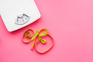 Slim concept. Scale and measuring tape on bright pink background top view space for text