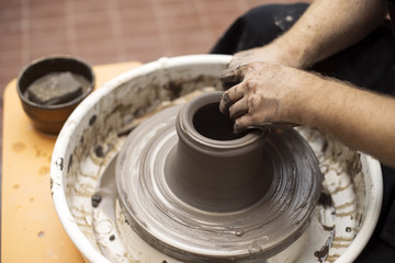 Artist makes clay pottery on a spin wheel