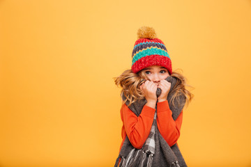 Young girl in sweater, scarf and hat having cold